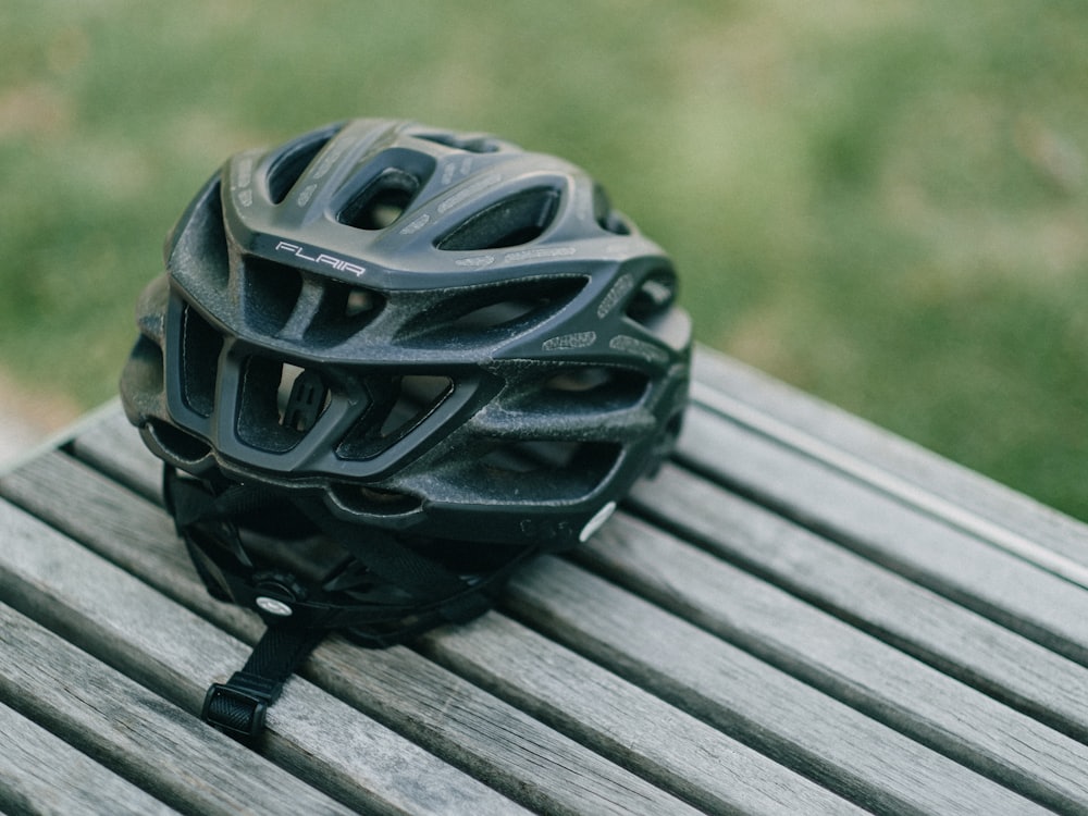 Schwarzer Fahrradhelm auf einer Holzbank